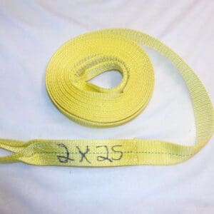 A yellow tow strap on top of a bed.