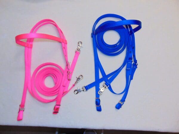 Two different colored leashes and a harness on top of a table.