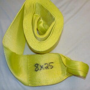 A yellow tow strap with the words " 8 x 2 5 ".