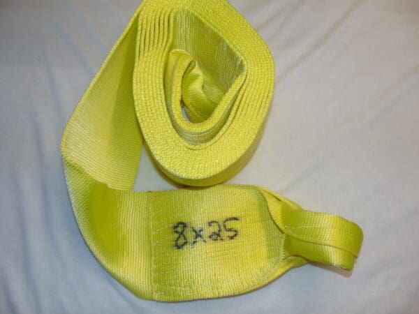 A yellow tow strap with the words " 8 x 2 5 ".