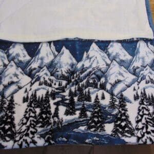 A blanket with trees and mountains on it