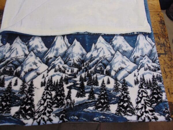 A blanket with trees and mountains on it