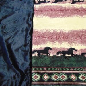 A close up of the blanket with horses on it