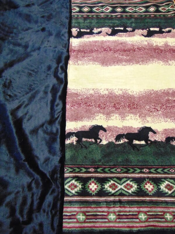 A close up of the blanket with horses on it