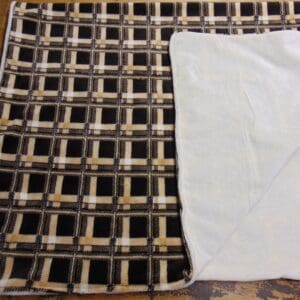 A blanket with a white border and black squares.