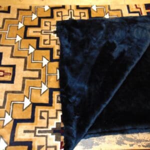 A black blanket on top of a wooden floor.