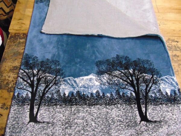 A painting of trees and mountains on the ground.