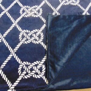 A blanket with white rope and blue squares on it.