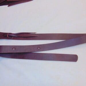 A pair of brown leather straps on top of a table.