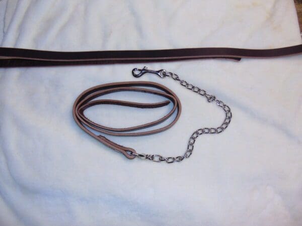 A brown leather leash with chain attached to it.