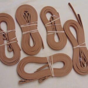 A group of six pairs of brown leather laces.