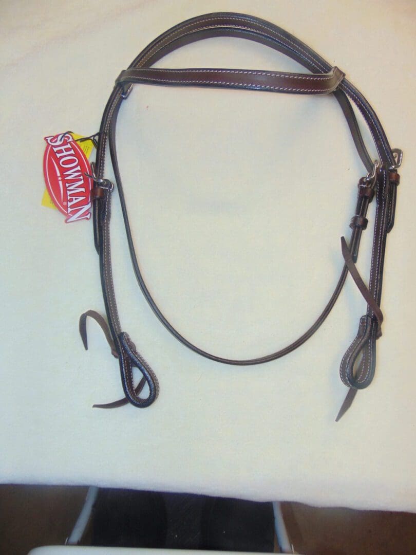 A brown leather bridle with a black reins.