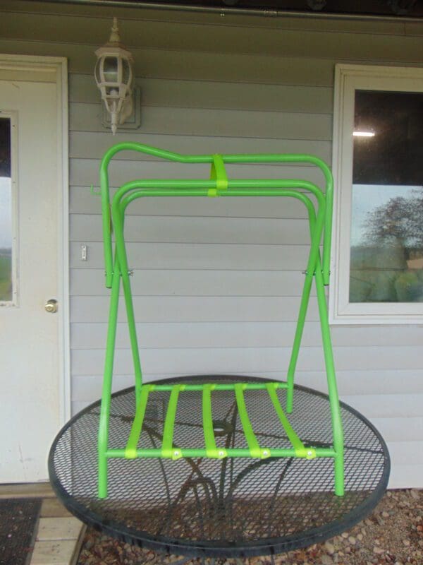 A green bicycle rack sitting on top of a metal table.