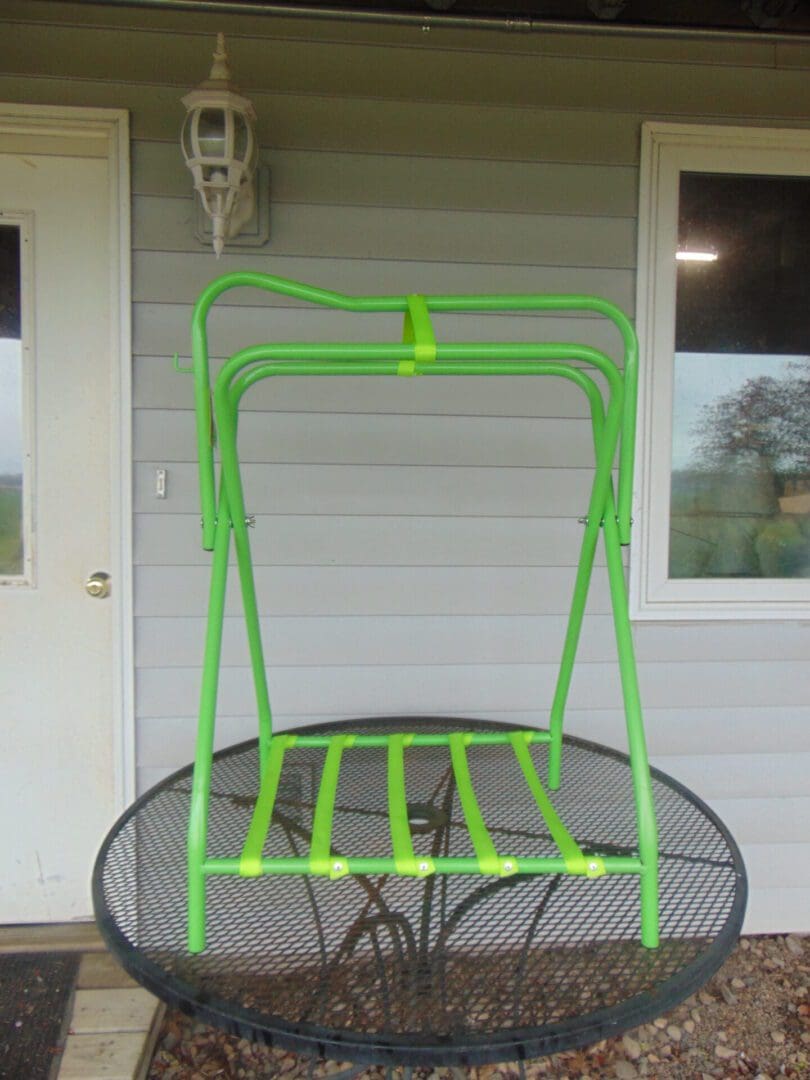 A green bicycle rack sitting on top of a metal table.